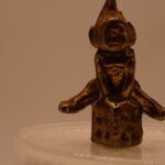 Brass Gnome sitting on a dice